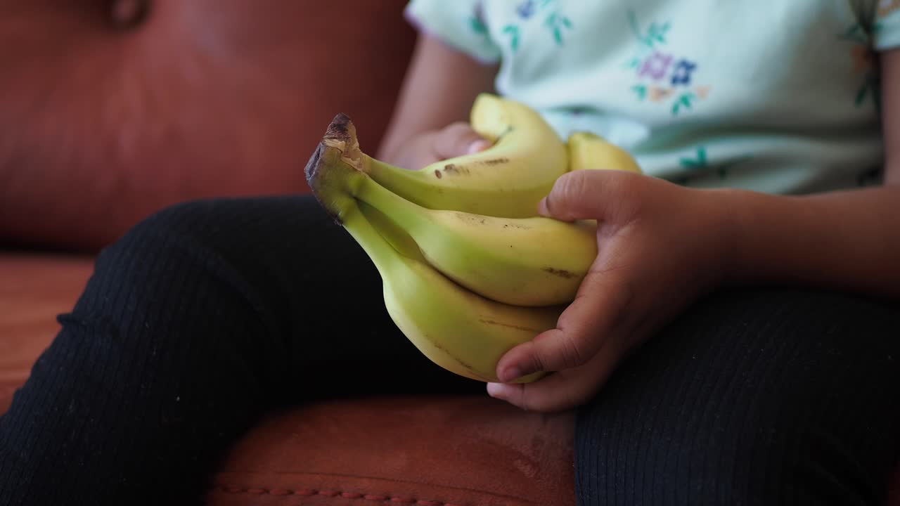 바나나 한 어리를 들고 있는 아이