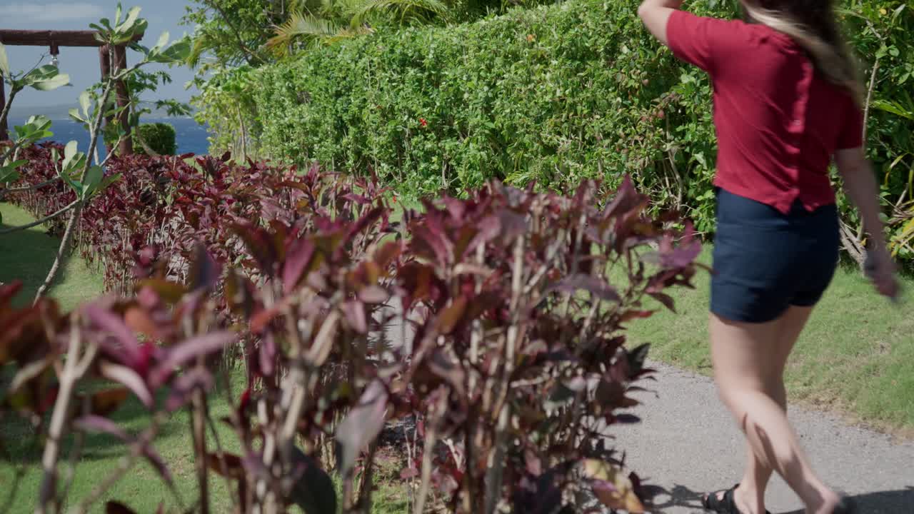 vista lateral y posterior de una niña caminando en un parque durante una mañana soleada y ventosa