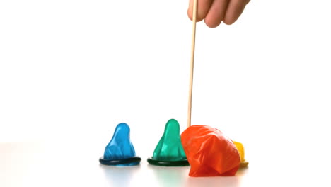 Cocktail-stick-popping-blown-up-condom-with-revealing-three-condoms