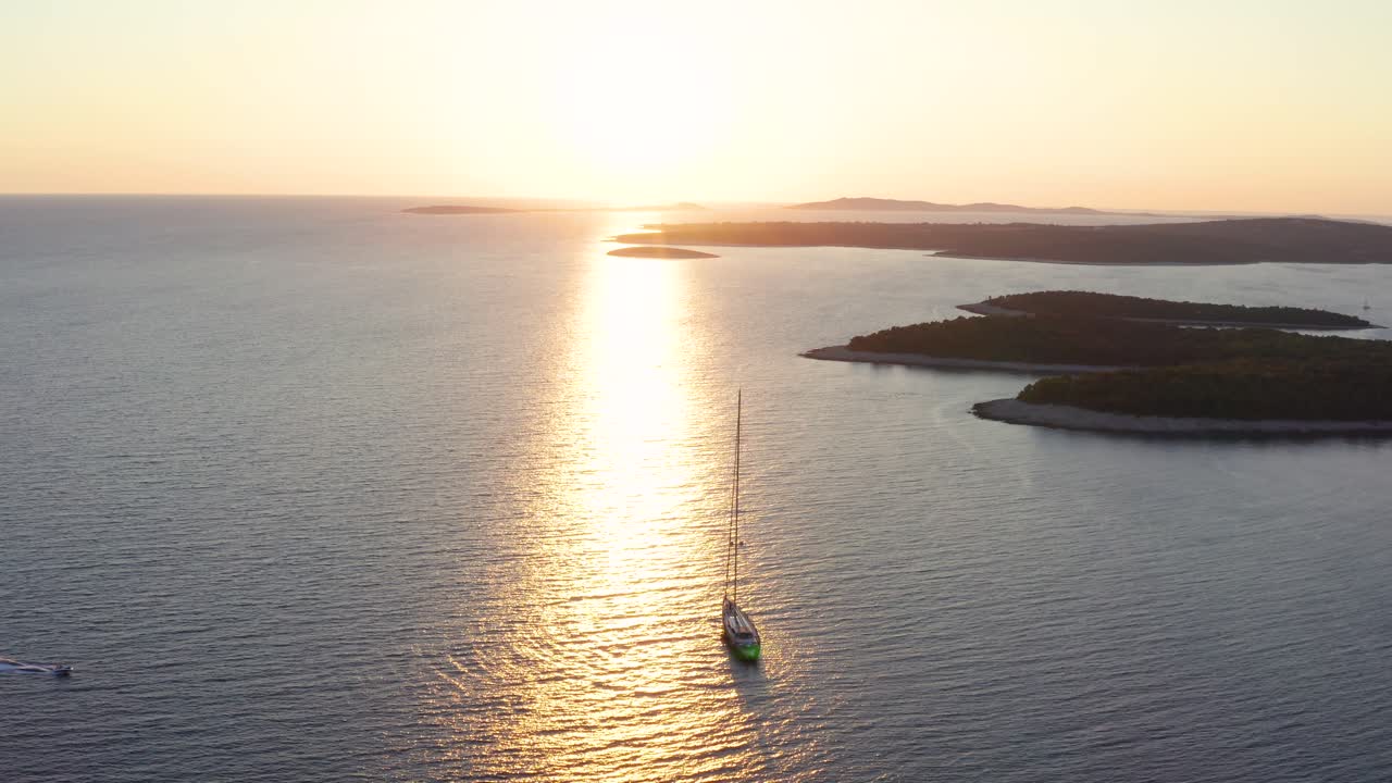 Barca a vela che naviga nel Mare Adriatico con splendidi riflessi della luce solare sulla superficie vicino all'isola di Lussino in Croazia.