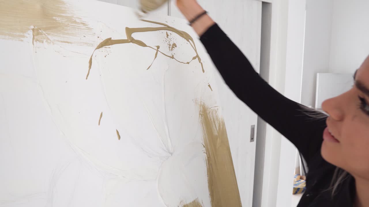 스튜디오의 대형 캔버스에 작품을 만드는 아름다운 라티나 화가 - 핸드헬드 샷