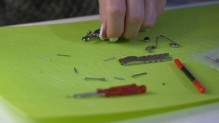 Female Watchmaker Repairing silver watch on table,close up shot