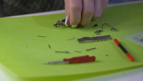 female watchmaker repairing silver watch on table,close up shot