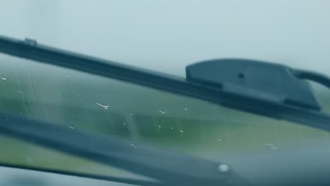 vista desde el coche limpiador de metal negro funciona bajo una lluvia ligera