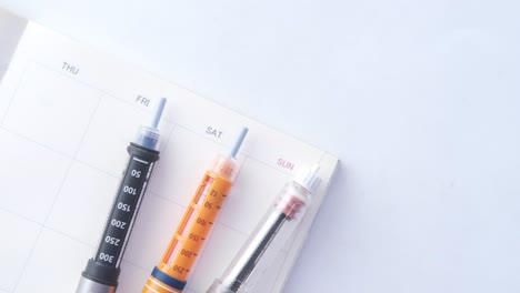 insulin pens and a calendar