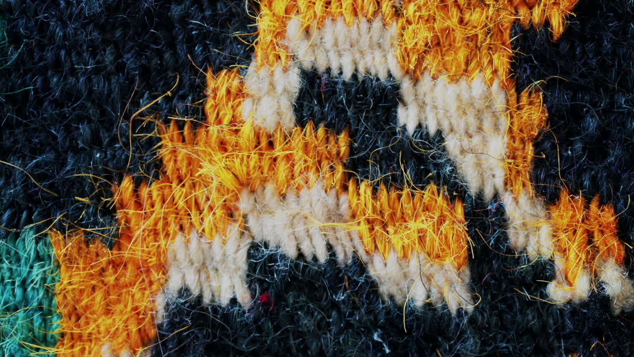Close up view of woven wool fibers in warm yellow and black tones