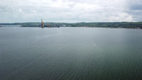 aabenraa harbor, denmark, with calm water and distant industrial structures, viewed from a drone