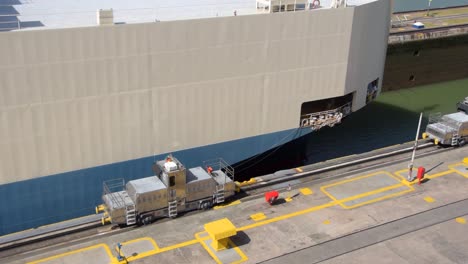 un enorme buque de carga que transportaba automóviles cruzando una de las puertas del canal de panamá