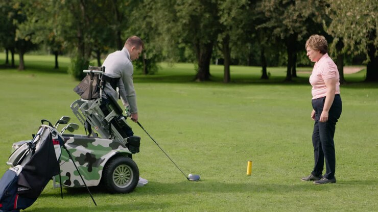 Un golfista con disabilità che gioca a golf con un assistente