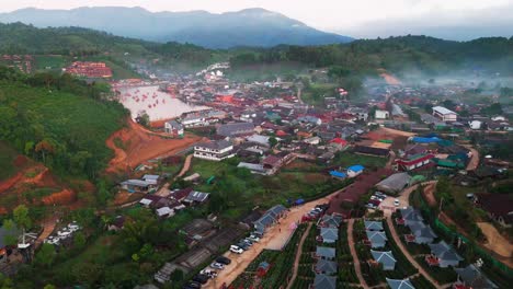 aerial panoramic dolly of ban rak thai village in northern thailand, surrounded by mountain mist and lush green forest