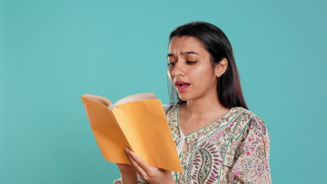 Cheerful-woman-smiling-while-enjoying-reading-activity,-holding-book