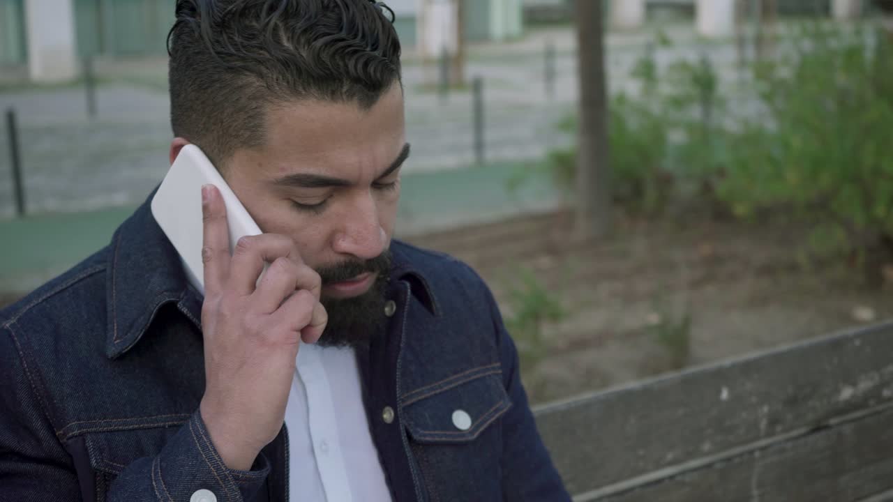 휴대 전화로 이야기 하는 노트북을 가진 심각한 남자