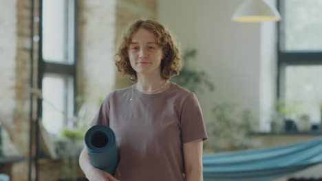 portrait of young cheerful woman in yoga studio