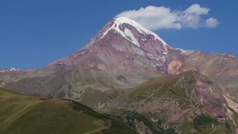 drone ascends above gergeti trinity church with view of powerful mount kazbek