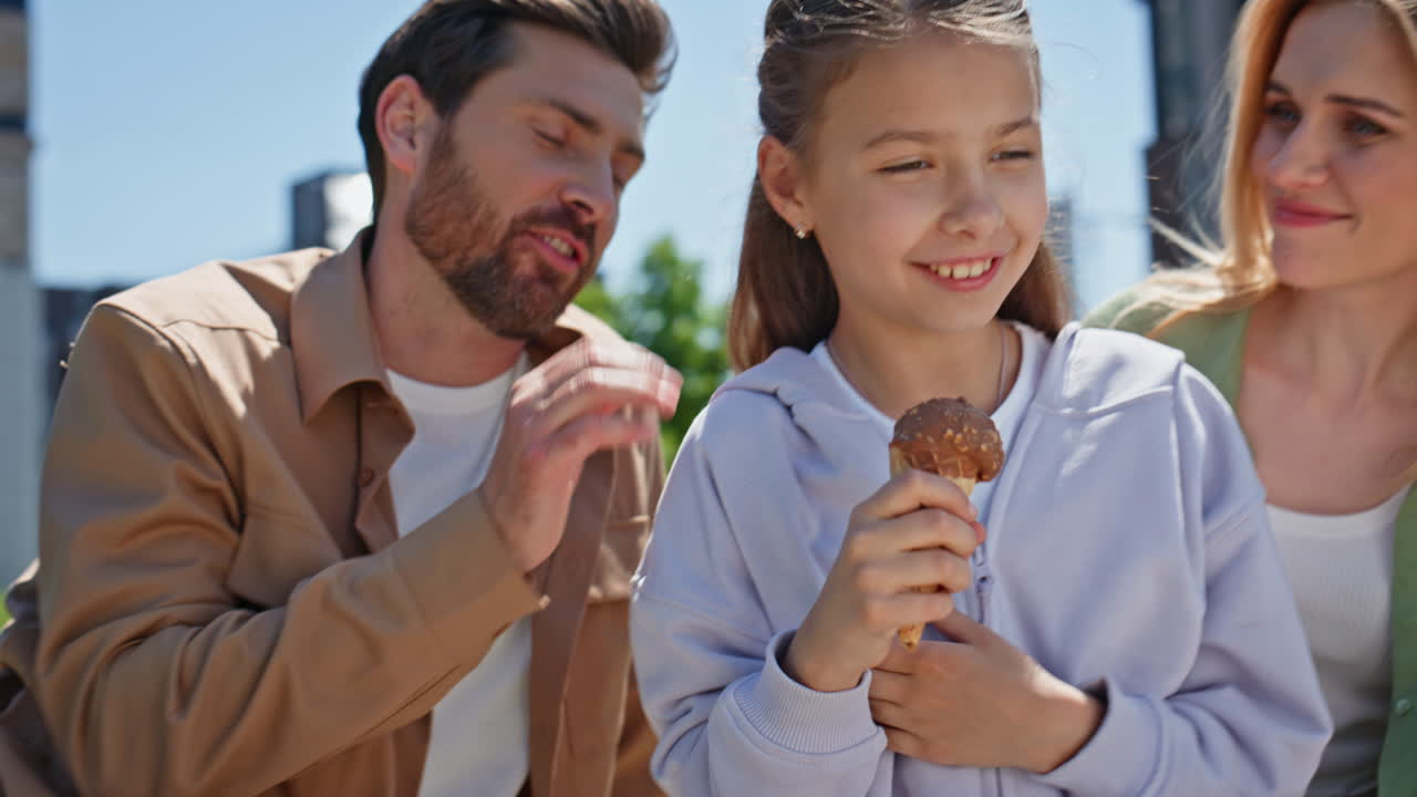 Overjoyed relatives holding ice-cream in summer picnic on green lawn closeup