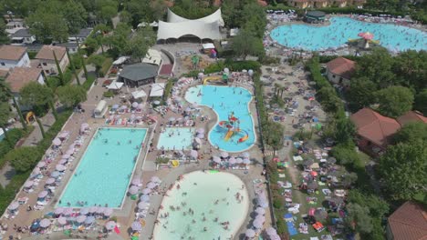 aerial shot of people swimming in pool resort in camping bella italia at lake garda, italy