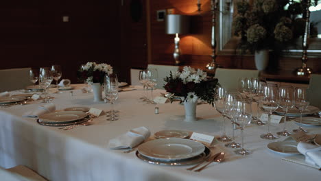 elegant dining table with fine cutlery, wine glasses, and plush chairs in a formal setting, prepared for a high-level diplomatic dinner.