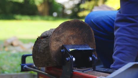 Close-up-of-man-using-log-splitting-machine-successfully-and-also-getting-splinter