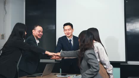 business people join putting hands as team during their meeting