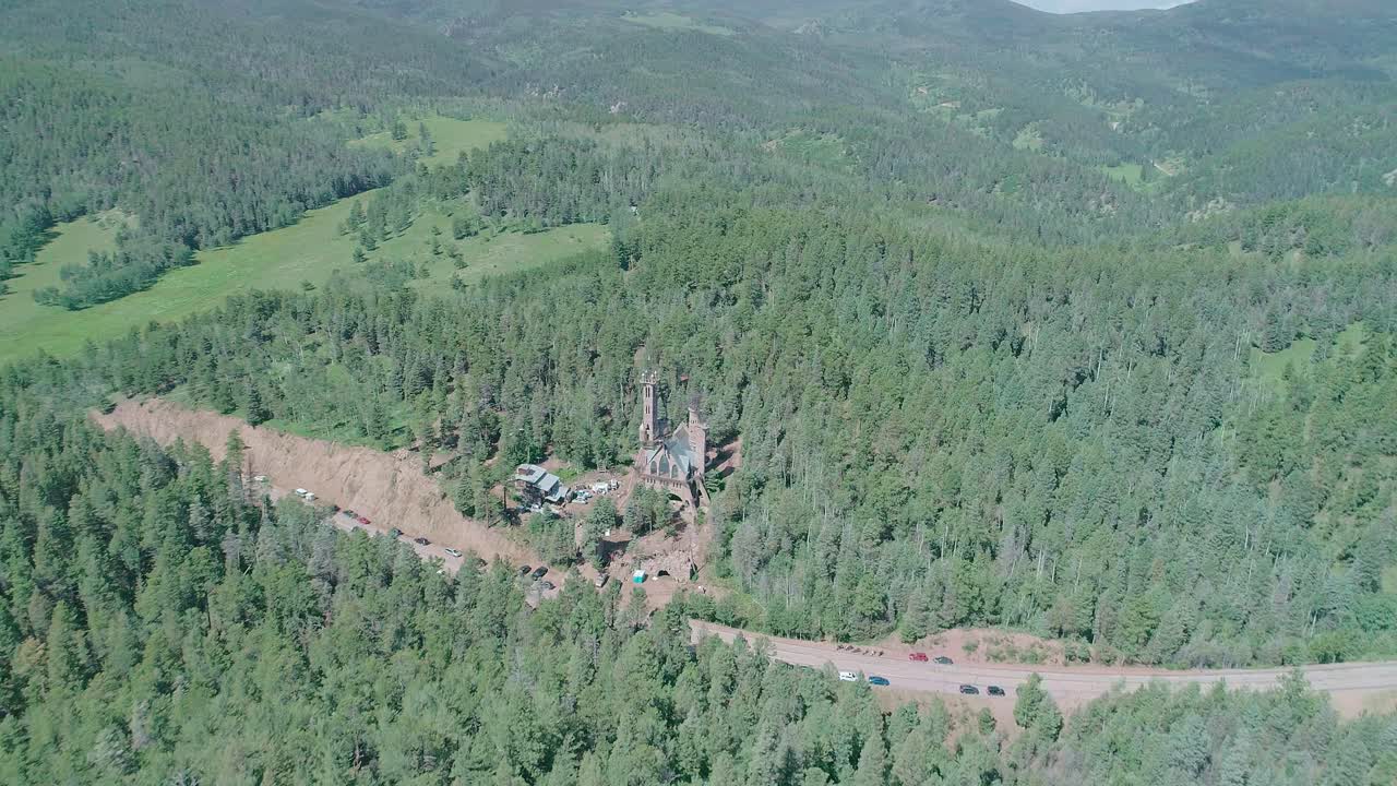 вид с беспилотника на небольшой замок посреди леса в колорадо