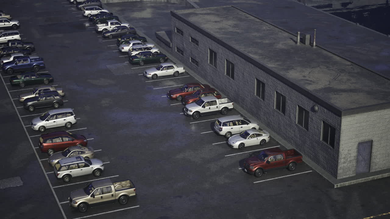 Cars parked in a lot near an industrial building during twilight