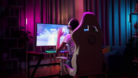 una adolescente asiática pierde mientras juega a videojuegos en la computadora, jugando a un videojuego de carreras.