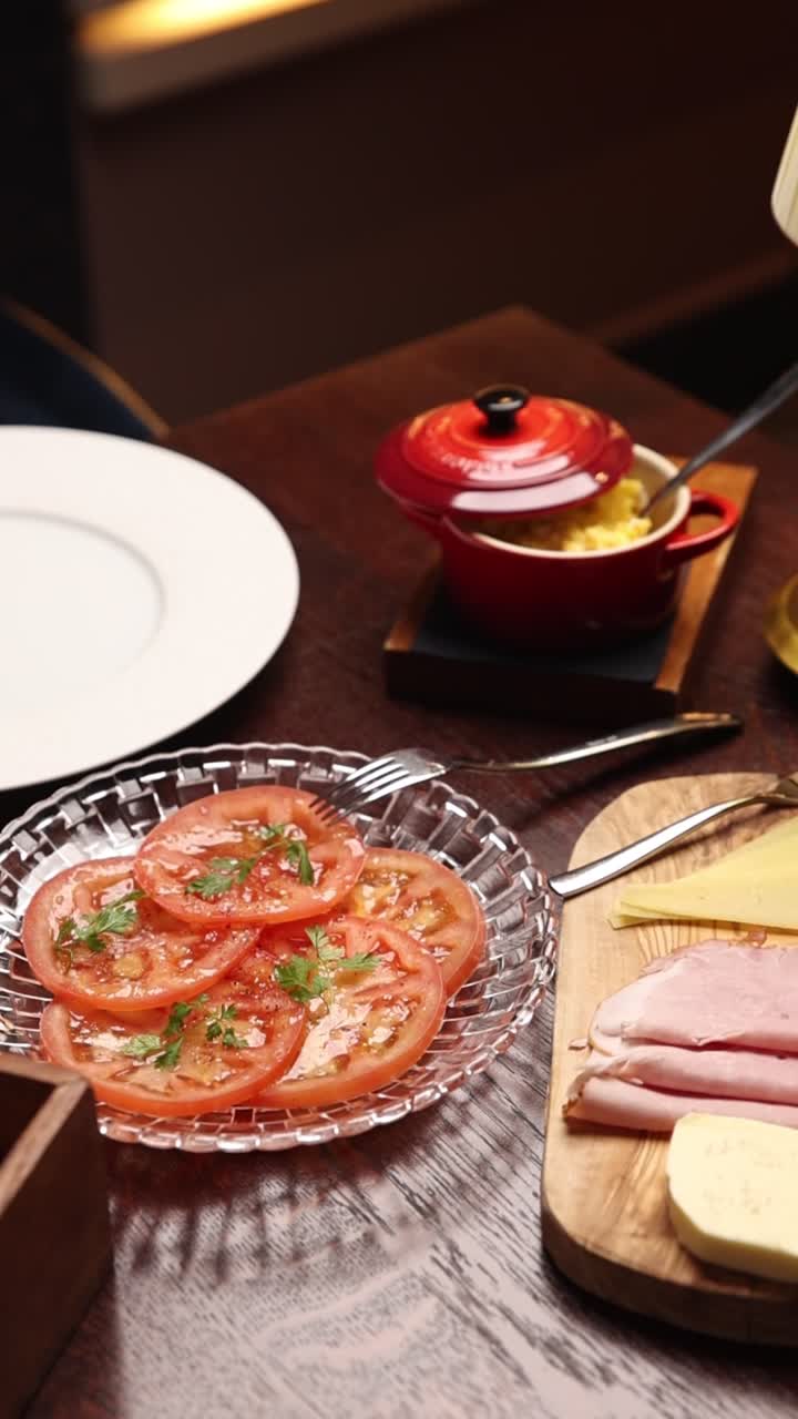 Ricca colazione invitante con pomodori a fette, prosciutto e formaggio