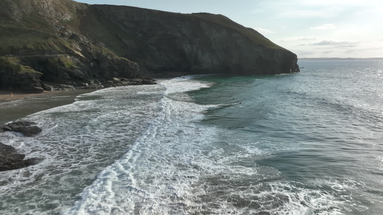 Trebarwith beach, Cornwall, aerial flight across beautiful sea to headland cliffs over surfers - mavic 3 cine prores 422 - Clip 3