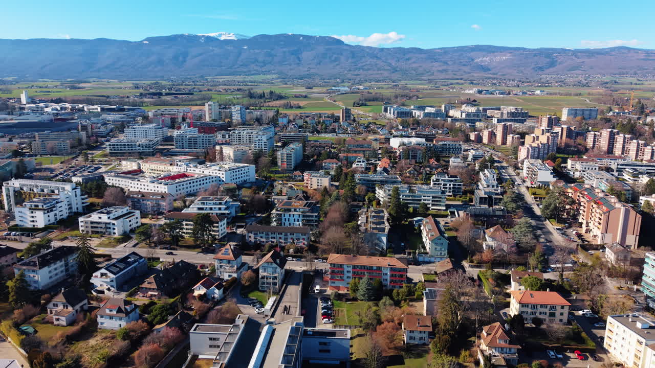 Flygfoto: Nyons stadskärna dagtid med berg i kantonen Vaud, Schweiz, etablerande drönarvy.