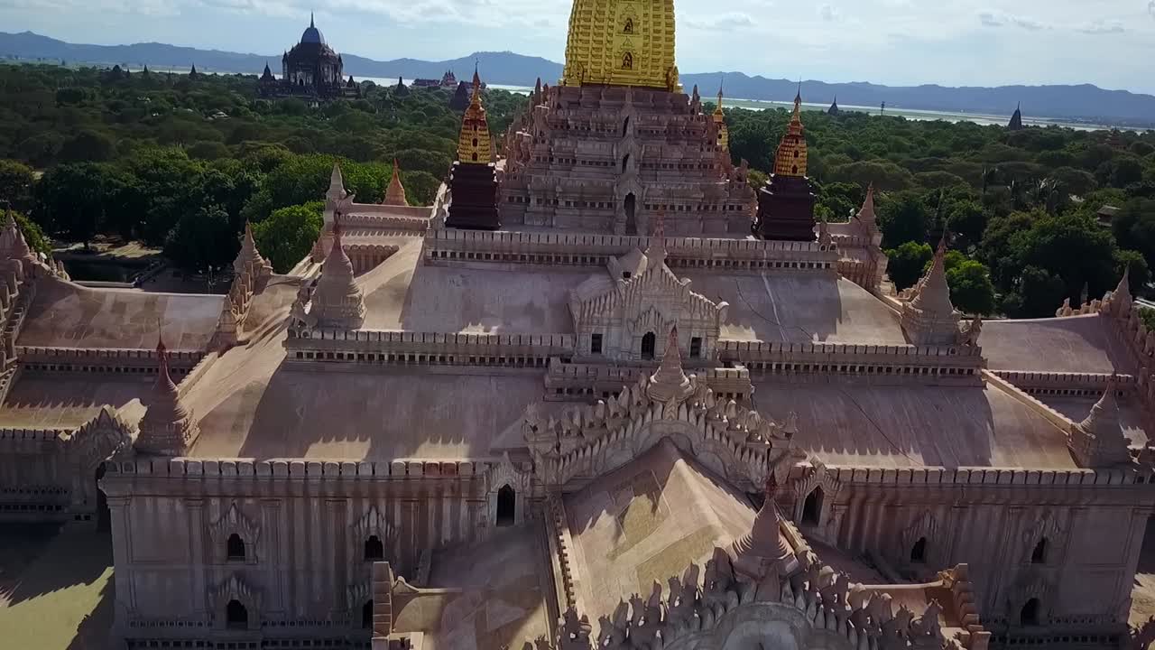 A cinematic tilt-up reveal shot of the White Temple at Ananda Temple in Bagan, Myanmar, beautifully showcasing the golden Sertok and the temple’s majestic architectural details.