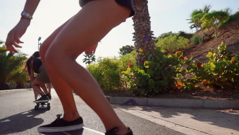 Two young Hispanic women leisurely skateboard on island paths, their movements captured in slow motion against the sunset&#039;s warm hues and palm trees. This showcases happiness and a healthy lifestyle