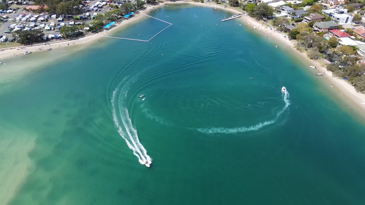 lanchas rápidas acelerando y dejando estela en el agua azul turquesa - tallebudgera creek - gold coast, qld, australia