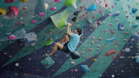 man bouldering on an indoor climbing wall