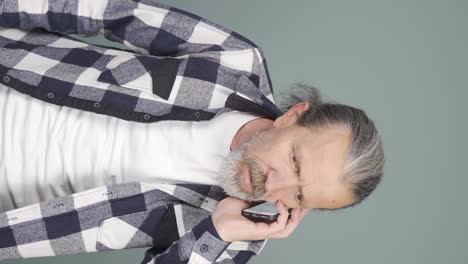 Vertical-video-of-Old-man-getting-bad-news-on-the-phone-gets-upset.