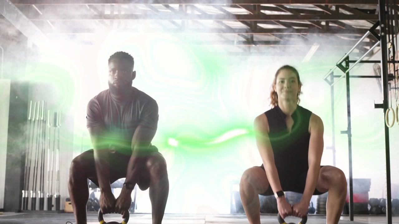 Compagni di palestra che oscillano kettlebell, muovendo i fianchi, allenandosi con un vortice verde che si muove sui corpi.