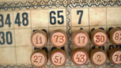 cinematic close-up smooth tilt down, shot from above of a bingo wooden barrels, woody figures, old numbers background, vintage board game, lucky number, professional lighting, slow motion 120 fps