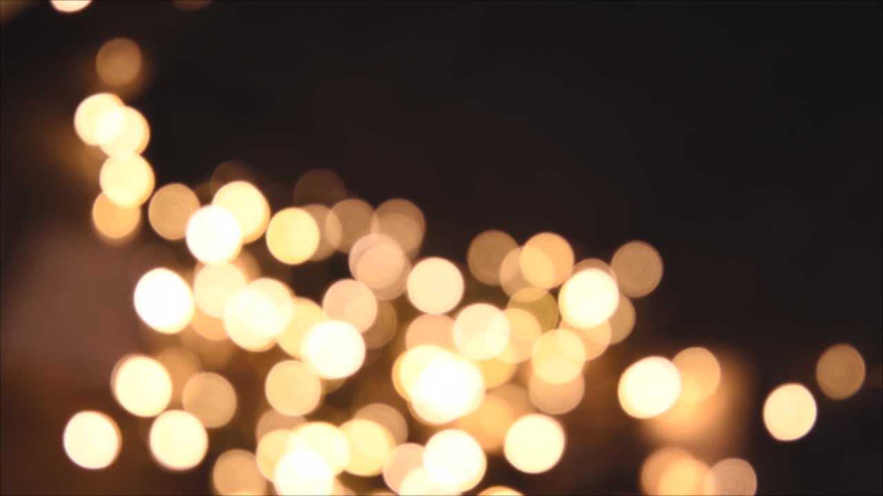 Christmas lights, shimmering abstract golden warm circles defocused. Blurred fairy lights. Out of focus holiday background. Light bokeh from Xmas tree. New Year theme, background 4k footage