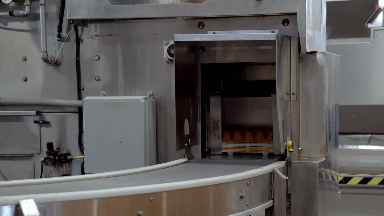 Yellow egg trays moving on a conveyor belt in an industrial packaging