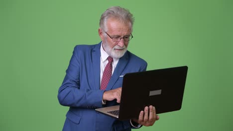 hombre de negocios barbudo y guapo contra un fondo verde.