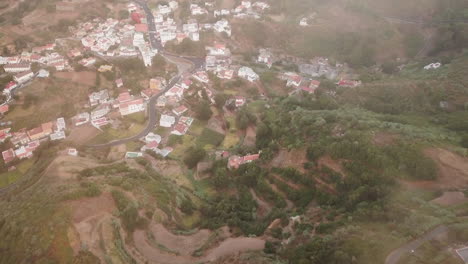 Aerial-view-of-the-city-of-Valleseco-passing-through-a-sea-of-​​clouds-and-during-sunset