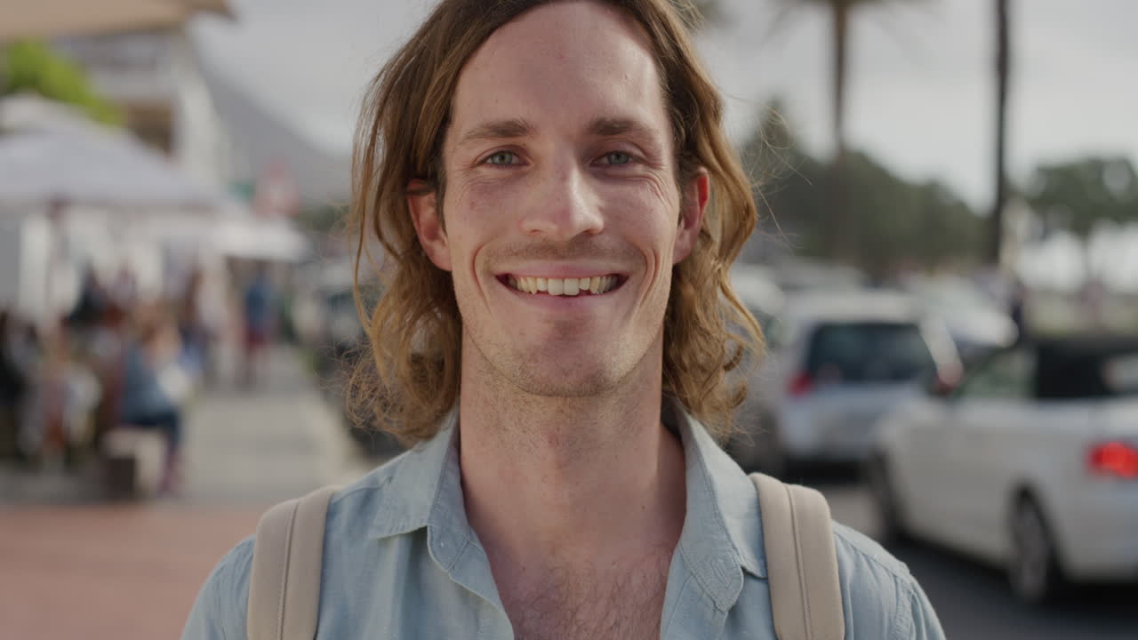 ritratto di un giovane uomo caucasico felice che sorride godendo di uno stile di vita di vacanza indipendente un bel turista di sesso maschile sulla soleggiata strada urbana sul lungomare in slow motion