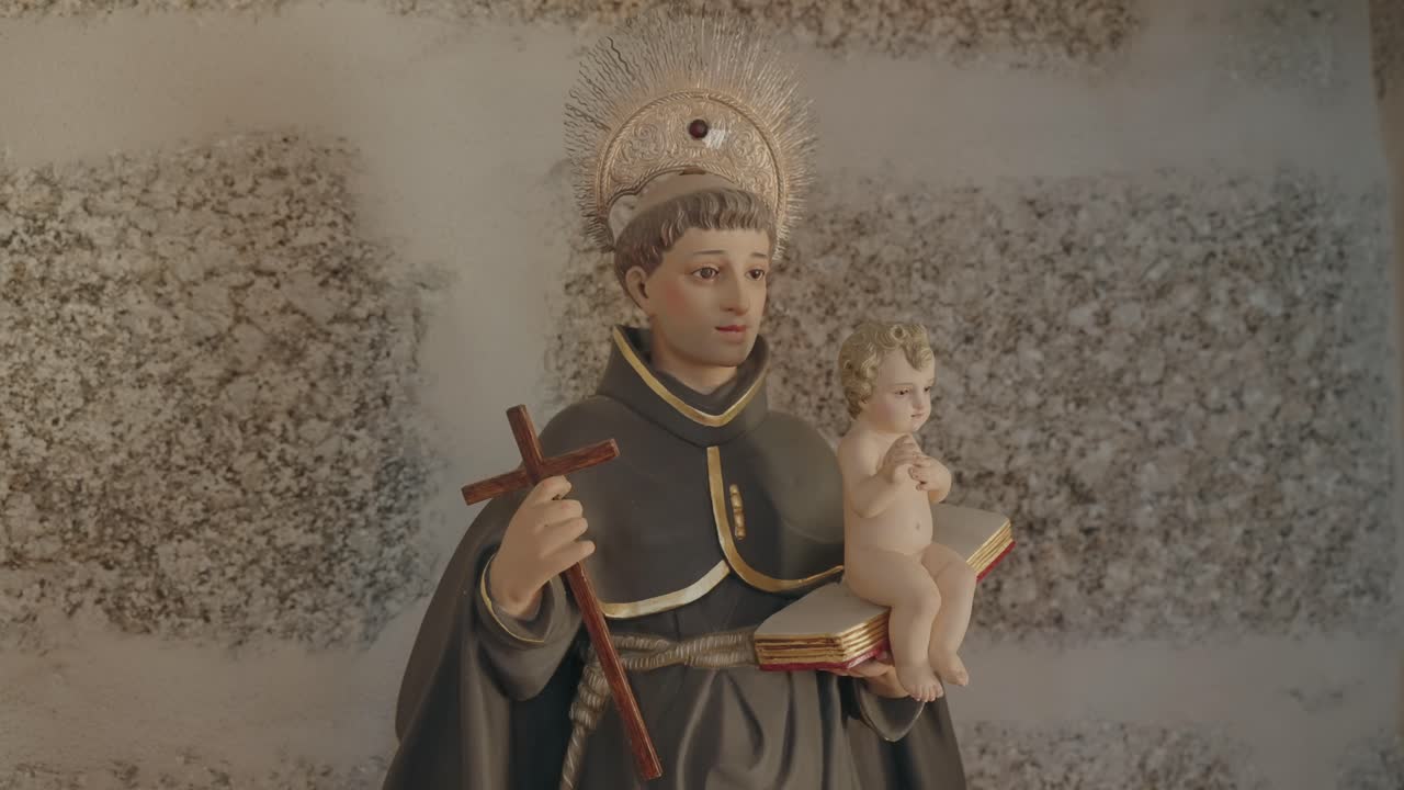 Religious statue of Saint Anthony with Child Jesus and cross in Portuguese church