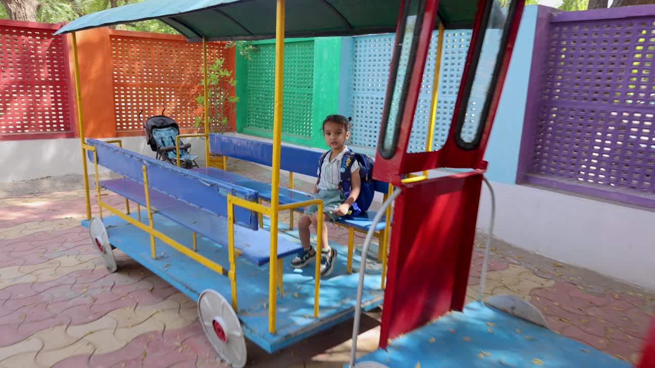indian child enjoying dummy train seating at preschool at outdoor