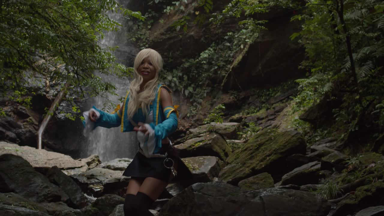 lucy 코스플레이어가 트리니다드 정글의 거대한 폭포 아래에서 포즈를 취하고 있습니다.