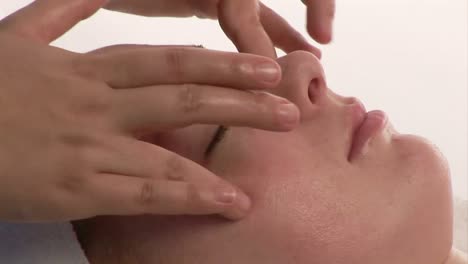 una mujer recibiendo un masaje facial