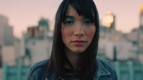 retrato de una hermosa joven asiática en el techo al atardecer con maquillaje colorido buscando confianza en la ciudad urbana