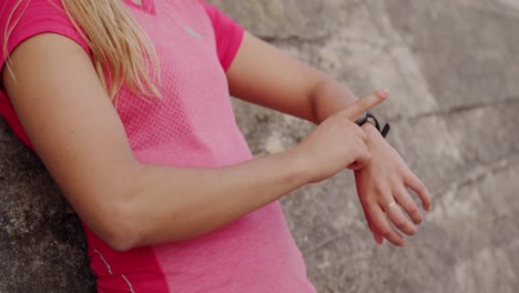 Woman-looking-at-her-watch-against-a-wall