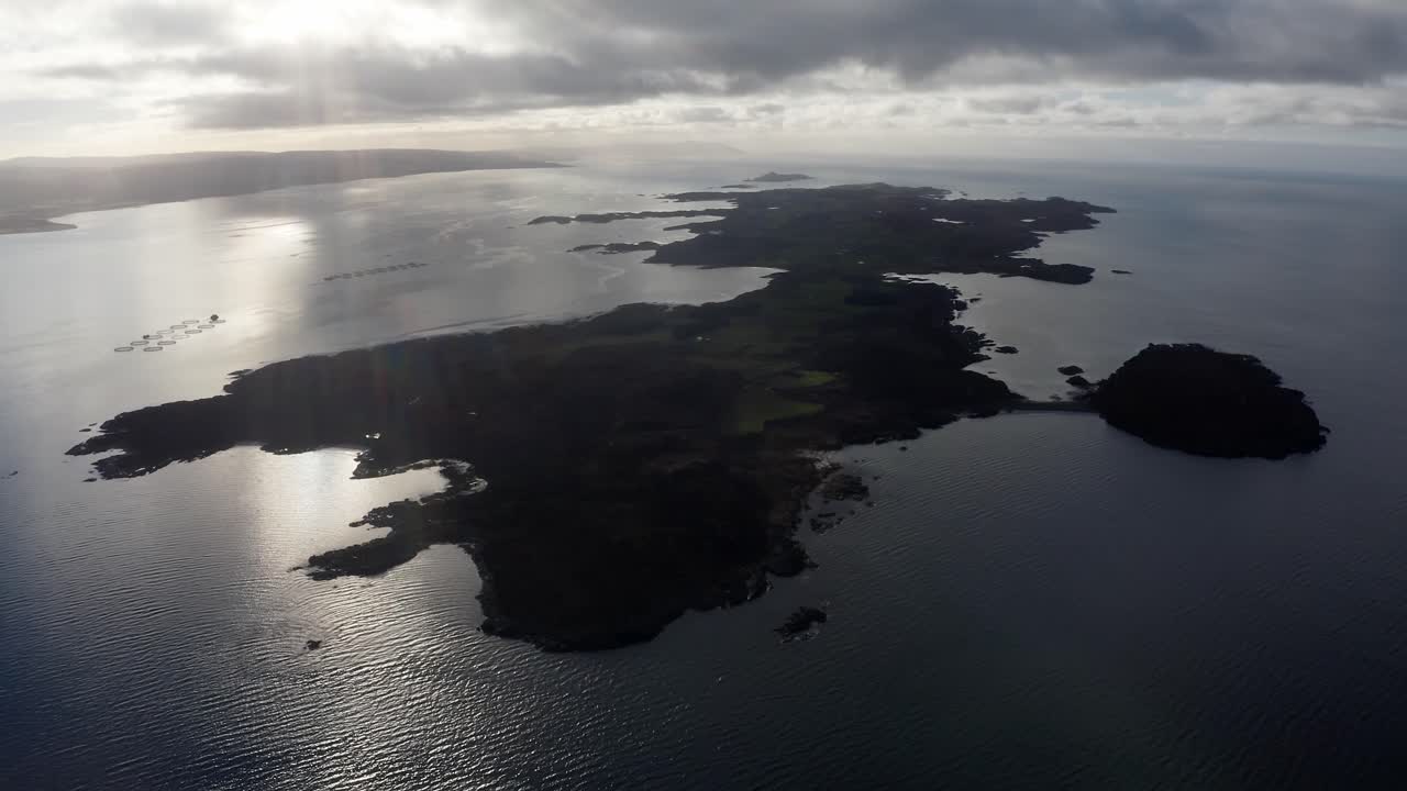 AERIAL - Silhouette of the Isle of Gigha at sunrise, Kintyre, Scotland, rising