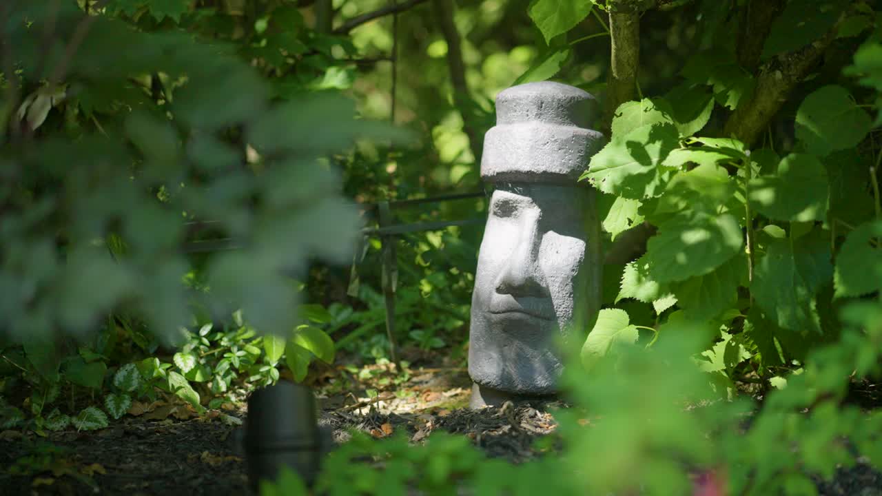 Uno scatto ravvicinato di una piccola statua dell'Isola di Pasqua nel giardino.