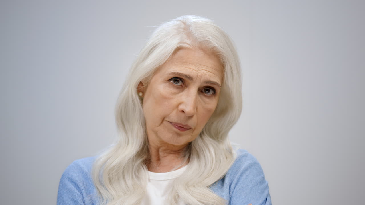Anziana donna frustrata che scuote la testa in studio. Signora turbata che incrocia le braccia al chiuso.